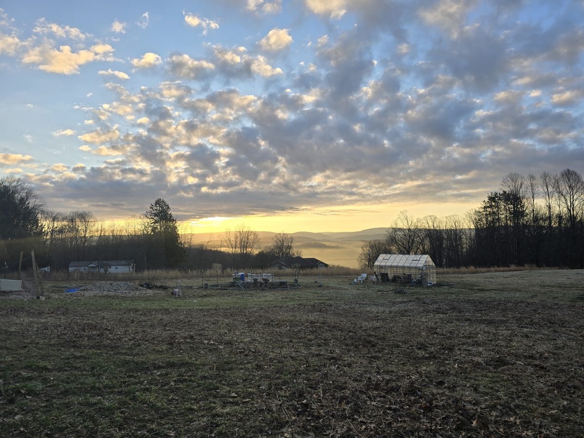 Golden sunset over the farm field and mountains